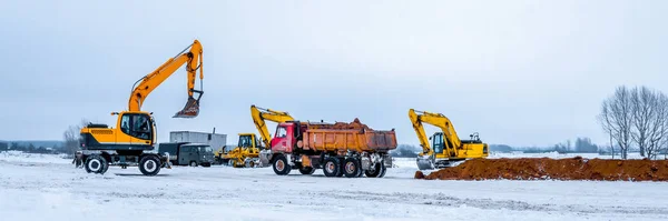 Construction truck tipping dumping gravel on road construction site,tip truck and ripper at work preparing ground for new housing estate,Dump truck unloading process