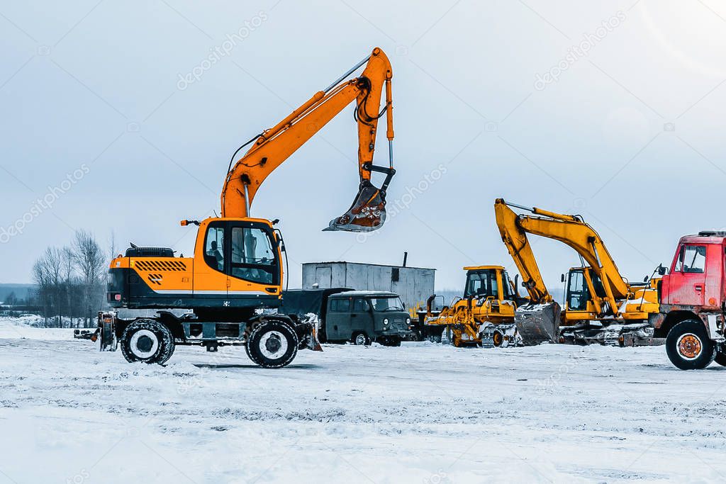 Excavator is loading excavation to the truck. Excavators hydraulic are heavy construction equipment consisting of a boom, dipper or stick , bucket and cab on a rotating platform