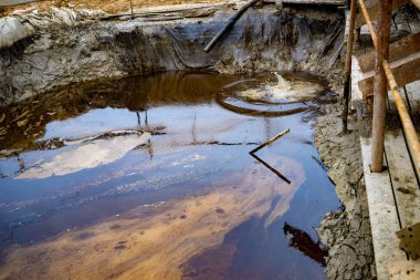 Sudaki petrol ve çöp kirliliği. Sığ alan derinliğiyle seçici odaklanma. Endüstriyel boru sıvı atığı boşaltıyor