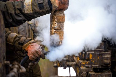 Offshore petrol kuyusu işçisi kuyu başındaki petrol kuyusunda delik açmak için alet ve ekipman hazırlayın. Sondaj borusu bağlantısı kuruyorum. Tribünlerin arasından matkap borusu bağlantısı için bir görünüm
