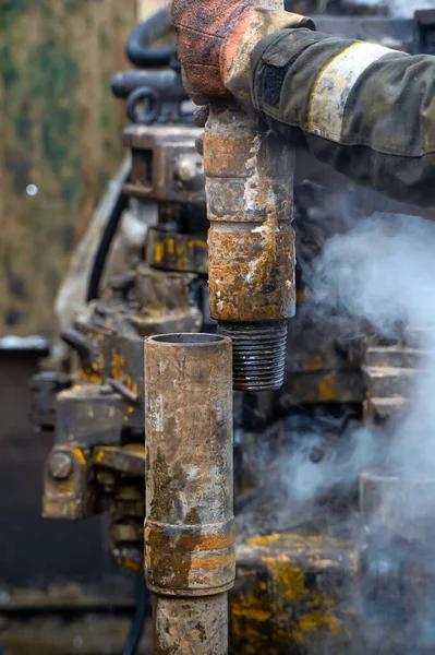 Offshore lavoratore piattaforma petrolifera preparare strumento e attrezzature per perforazione olio e gas bene a pozzo piattaforma. Sto creando un collegamento per il tubo di perforazione. Una vista per il collegamento del tubo di perforazione tra gli stand — Foto Stock