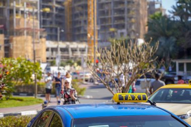 Şehir merkezindeki bir otoyolda yüksek hızda bir taksi. Çatısının tepesinde yanan bir taksi var.