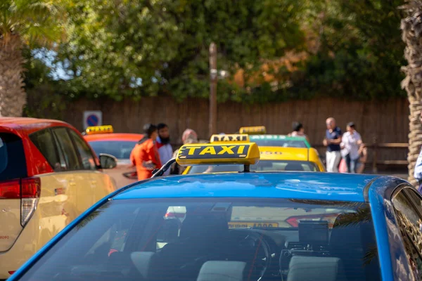 Egy kép egy fiatalemberről sapkában és kockás ingben, aki a hátsó ülésen ül sárga taxiban. Boldog férfi beszáll egy taxiba. Üzletember beszáll egy taxiba a város utcájában.. — Stock Fotó