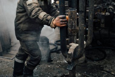 Offshore petrol kuyusu işçisi kuyu başındaki petrol kuyusunda delik açmak için alet ve ekipman hazırlayın. Sondaj borusu bağlantısı kuruyorum. Tribünlerin arasından matkap borusu bağlantısı için bir görünüm.