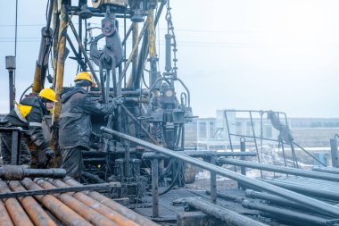 İşçi teçhizatı daha önce delinmiş bir kuyu üzerinde çalışıyor. Tamir yoluyla üretimi geri getirmeye çalışıyor. Offshore petrol kuyusu işçisi kuyu başındaki petrol kuyusunda delik açmak için alet ve ekipman hazırlayın.