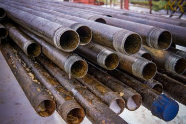 Petrol sondaj borusu. Paslı matkap boruları kuyu bölümünden delinmiş. Delik sondaj kulesi. Güverteye boru döşemek. Petrol ve benzin deposunun avlusundaki sondaj borularının görüntüsü.