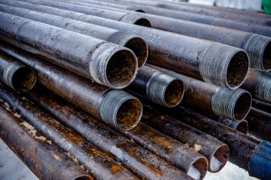 Petrol sondaj borusu. Paslı matkap boruları kuyu bölümünden delinmiş. Delik sondaj kulesi. Güverteye boru döşemek. Petrol ve benzin deposunun avlusundaki sondaj borularının görüntüsü.