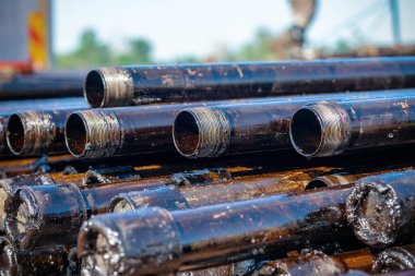 Petrol sondaj borusu. Paslı matkap boruları kuyu bölümünden delinmiş. Delik sondaj kulesi. Güverteye boru döşemek. Petrol ve benzin deposunun avlusundaki sondaj borularının görüntüsü.