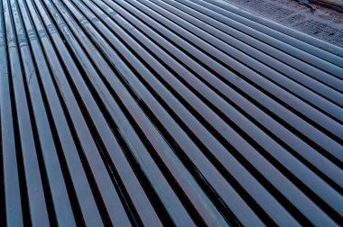 Doku yağı matkabı. Paslı matkap boruları kuyu bölümünden delinmiş. Delik sondaj kulesi. Petrol ve benzin deposunun avlusundaki sondaj borularının görüntüsü.