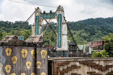 SHIFEN, TAIWAN - JUL 24, 2016: Jingan Suspension Bridge linked between Shifen and Nanshan Village at Shifen, Taiwan. clipart