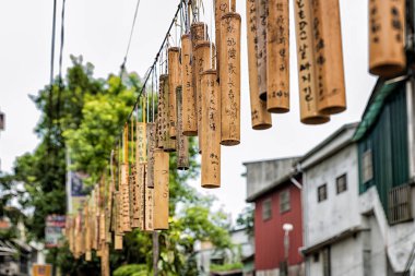 PINGXI, TAIWAN - June 24, 2016: Bamboo Tube for Wishing at Pingxi Old Street. Visitors write their wishes on bamboos then pray and hang them together. clipart