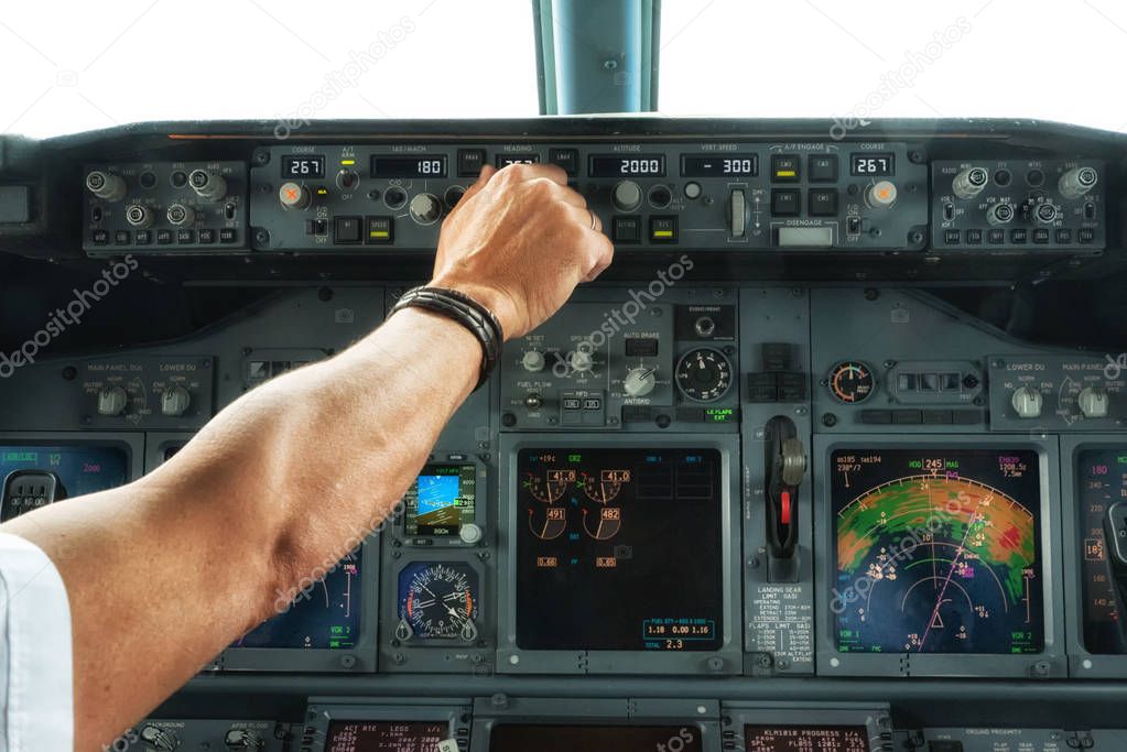 Pilot hand operate a switch on aircraft panels.