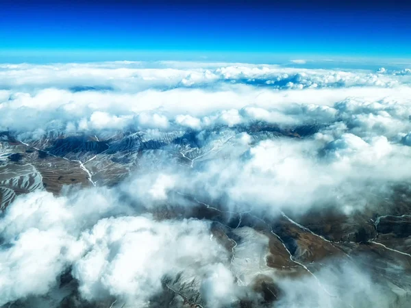 Aerial view of mountains and clouds on top — Stock Photo, Image