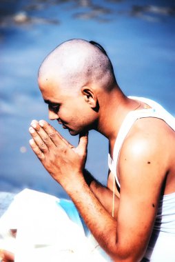 Kathmandu, Nepal - 11 October 2012: Nepalese Devotee offering religious puja along with butter lamps on the banks of the Bagmati River