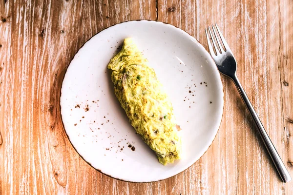 木制背景瓷盘上的传统早餐煎蛋卷 — 图库照片