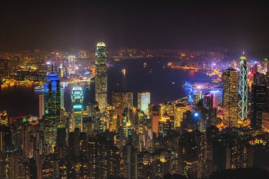 Geceleri Çin 'deki Hong Kong adasında manzara. Victoria Tepesi 'nden aydınlık gökdelenleri görünen çok renkli gece gökdelenleri
