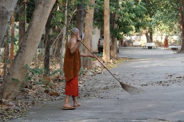 Tayland tapınağında düşen yaprakları temizleyen keşiş