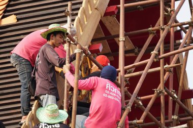 Tayland tapınağının çatısını döşeyen adamların yakın çekim görüntüleri.