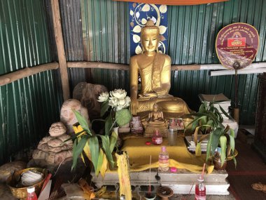 Küçük tapınakta çiçekli Buda heykeli