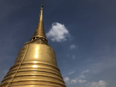 Mavi gökyüzünün önünde güzel altın bir stupa