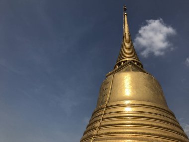 Mavi gökyüzünün önünde güzel altın bir stupa