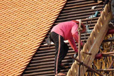 Tayland tapınağının çatısını döşeyen adamın yakın plan çekimi.