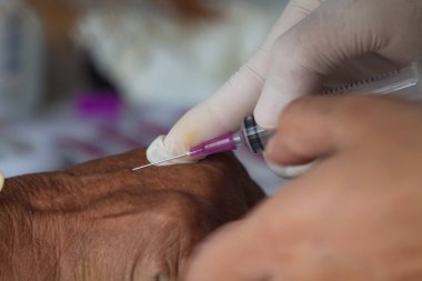 Doktor hasta kan toplamak için şırınga ile enjekte