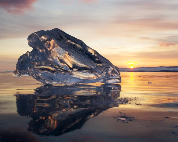 A piece of ice lying on the frozen surface of lake Baikal at daw — Stock Photo, Image
