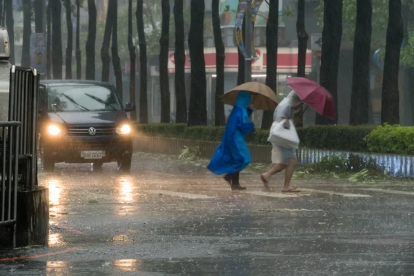 Pedestres cruzando a rua durante o tufão Megi — Fotografia de Stock