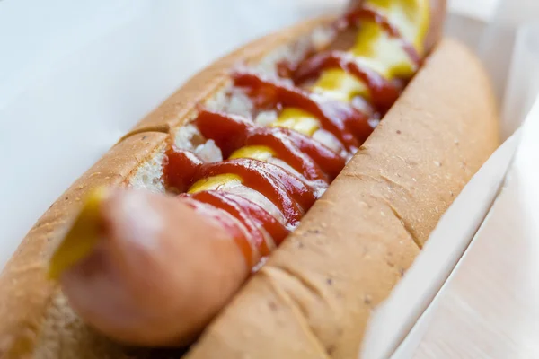 Hotdog with mustard and ketchup in white container — Stock Photo, Image