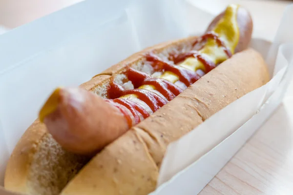 Hotdog met mosterd en ketchup in witte container — Stockfoto
