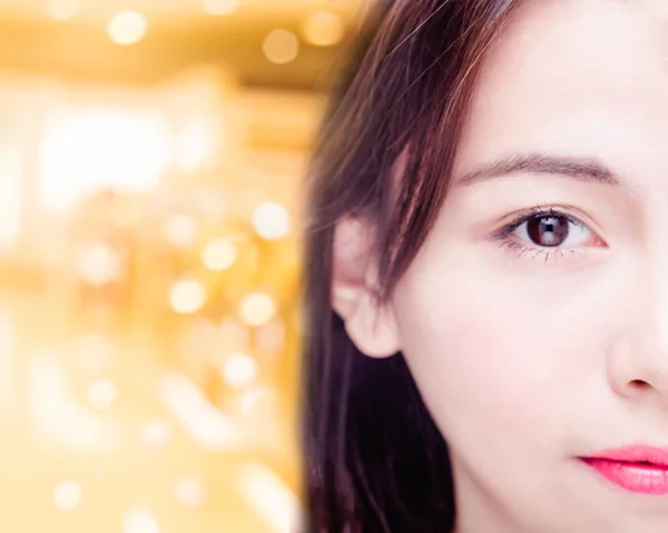 Hälfte des Gesichts einer asiatischen Frau auf goldenem Hintergrund — Stockfoto