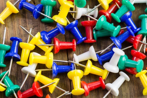 Various color thumbtacks  on distressed wood — Stock Photo, Image