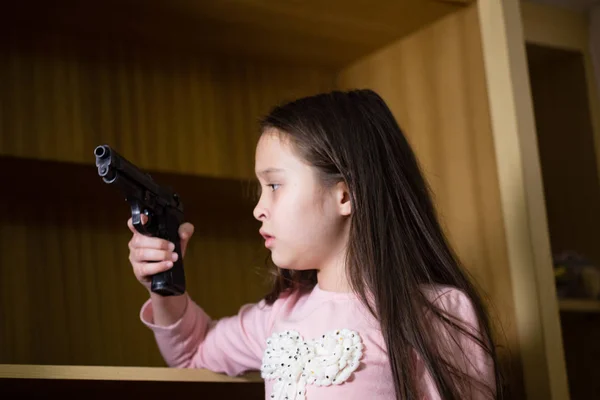 Молодая девушка находит пистолет в шкафу — стоковое фото