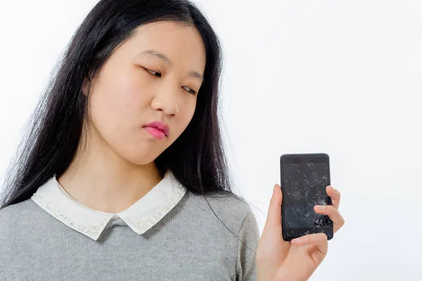 Asian schoolgirl with cracked cellphone — Stock Photo, Image