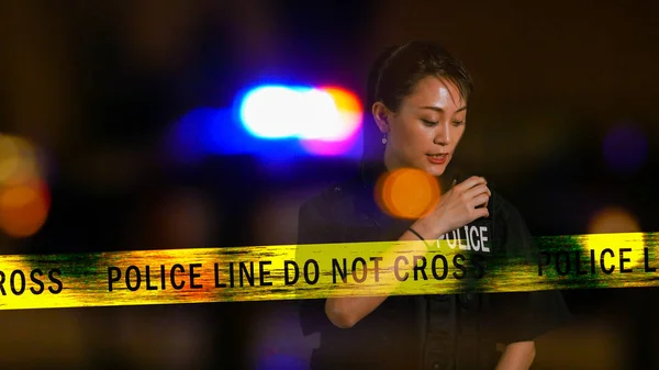 Asiática americana policewoman usando police radio —  Fotos de Stock