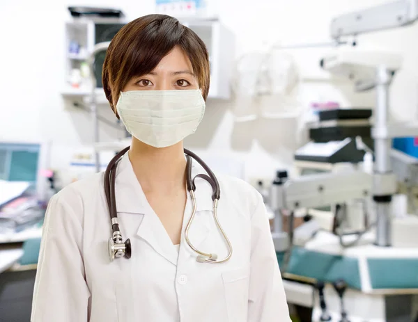 Asiatique femme médecin avec masque chirurgical regardant caméra en clin — Photo