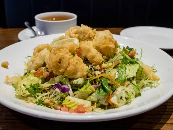 Calamares met salade met witte schotel — Stockfoto