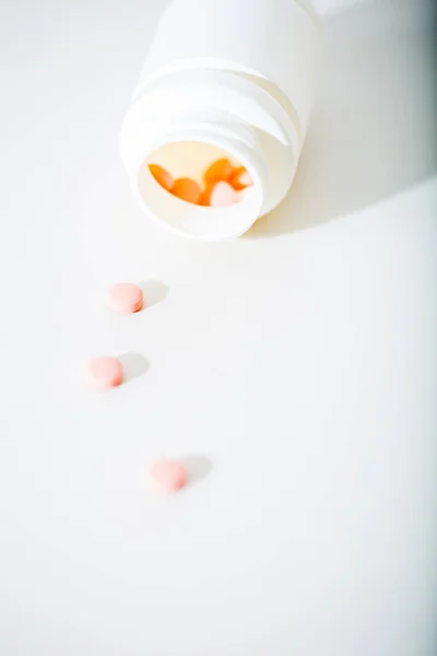 Macro shot of tablets and container — Stock Photo, Image