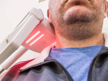Man getting UV heat treatment at clinic clipart