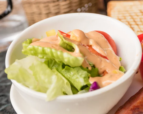 Salade in kommetje met roze dressing — Stockfoto