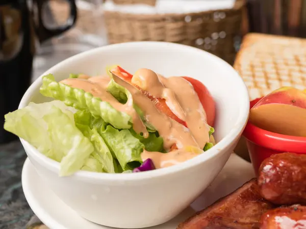 Salade in kommetje met roze dressing — Stockfoto