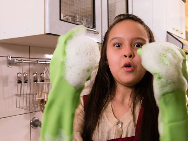 Asian  American girl washing dishes with funny expression — Stock Photo, Image