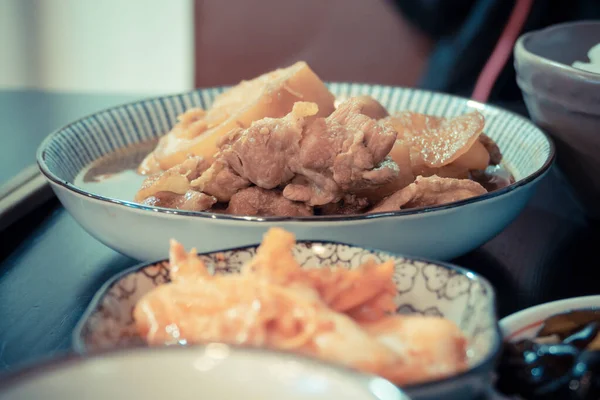 Prato de porco chinês na mesa com pratos laterais — Fotografia de Stock