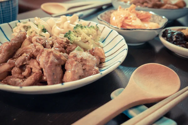 Chinese pork dish on table with side dishes — Stock Photo, Image