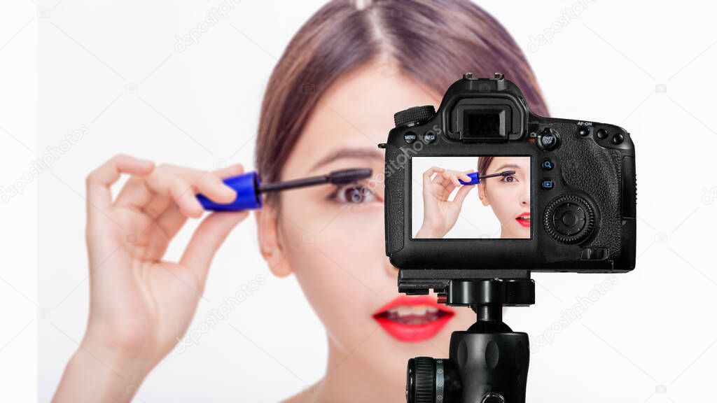 Asian female applying mascara, vlog concept