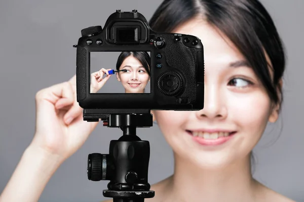 Asiático feminino aplicando rímel, vlog conceito — Fotografia de Stock