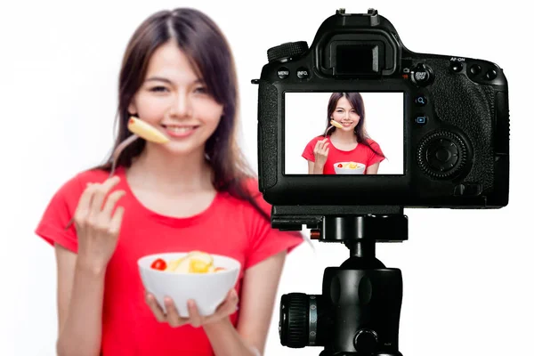 Asian food vlogger with fruit salad behind camera — Stock Photo, Image