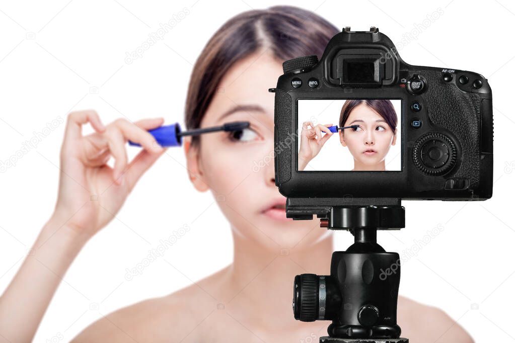 Asian female applying mascara, vlog concept