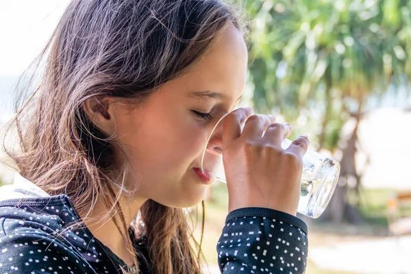 Tween girl drinks glass of water — Stok fotoğraf